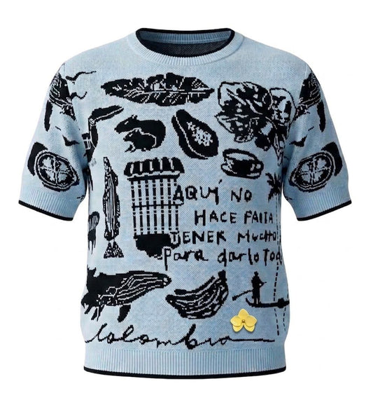 Camiseta tejida en hilo azul cielo con ilustraciones colombianas en negro — fauna, flora, café y la frase 'Aquí no hace falta tener mucho para darlo todo'. Colaboración solidaria OPHIA, Con Amor, Margot Tejido y Mucúra.